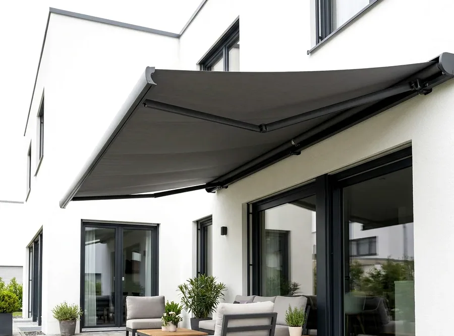 Folding-arm awning extended over a garden patio, fabric canopy on scissor arms with no posts beneath